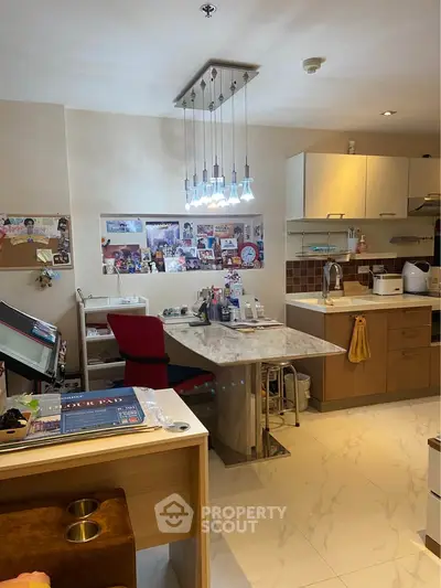 Modern kitchen with marble island and stylish lighting, featuring open layout and sleek cabinetry.