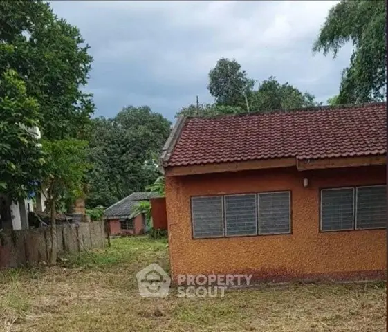Charming rustic house with red tiled roof and lush greenery, perfect for serene living.