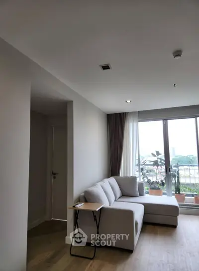 Modern living room with cozy sofa and large window offering city view