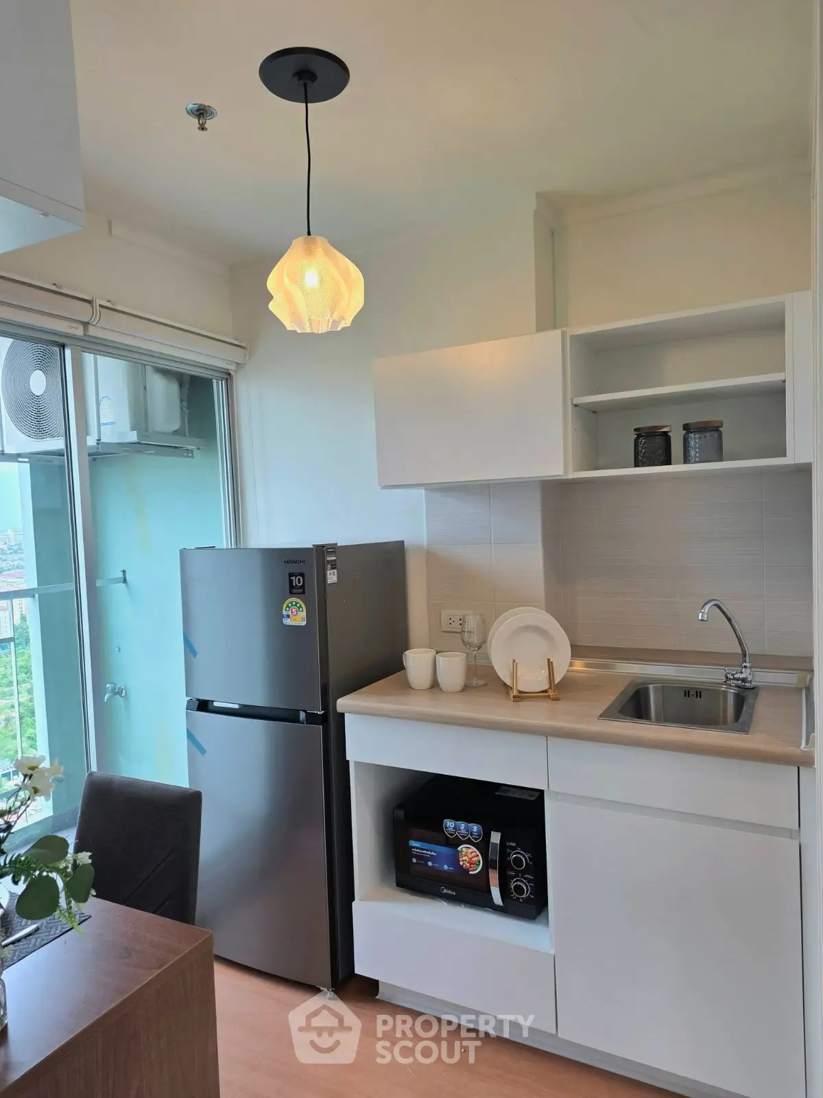 Modern kitchen with sleek appliances and stylish lighting in a cozy apartment setting.