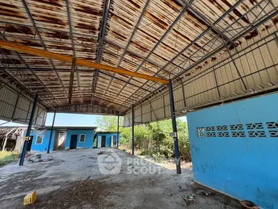 Spacious industrial warehouse with metal roof and blue exterior walls, ideal for storage or business use.