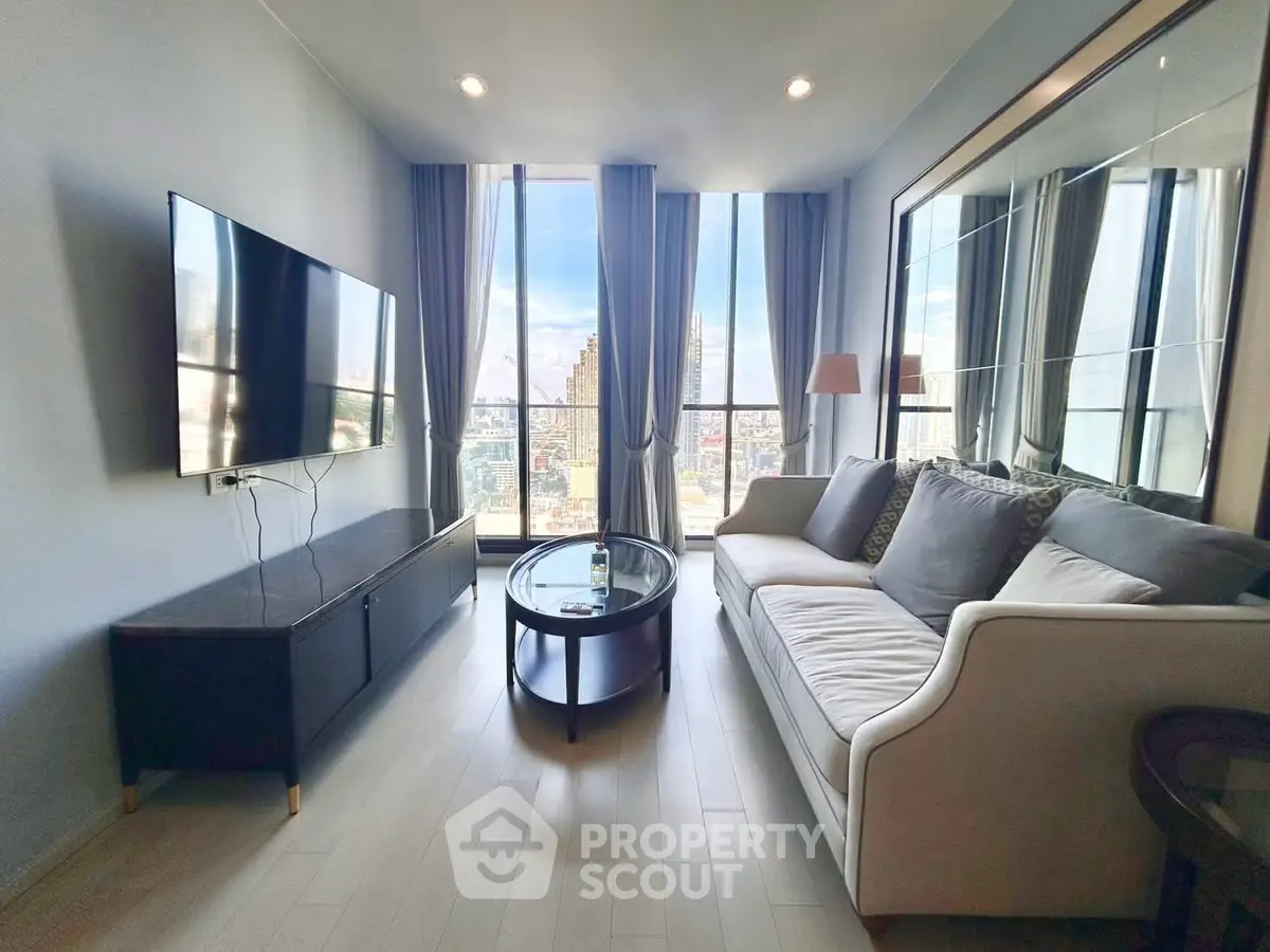 Modern living room with large windows and city view, featuring a sleek sofa and wall-mounted TV.