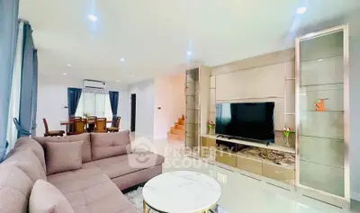 Spacious modern living room with elegant decor and open dining area, perfect for family gatherings.