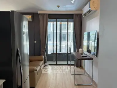Modern living room with balcony access, featuring sleek furniture and a large window for natural light.