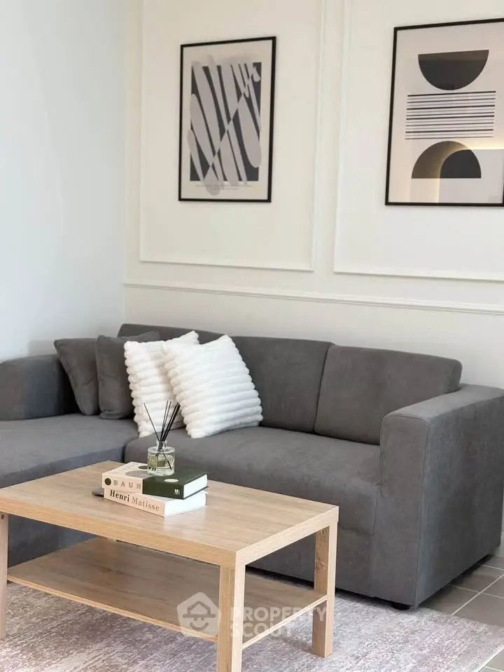 Stylish living room with modern gray sofa and elegant wall art