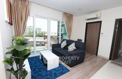 Modern living room with balcony view, featuring cozy sofa and stylish decor