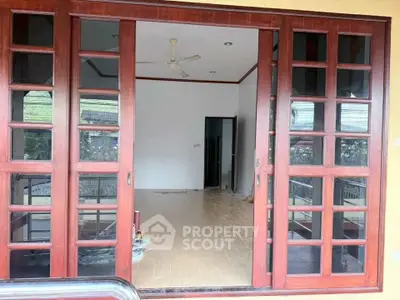 Spacious interior with wooden sliding doors and tiled flooring, perfect for modern living.