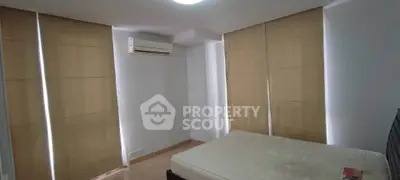 Spacious bedroom with air conditioning and natural light through large windows.