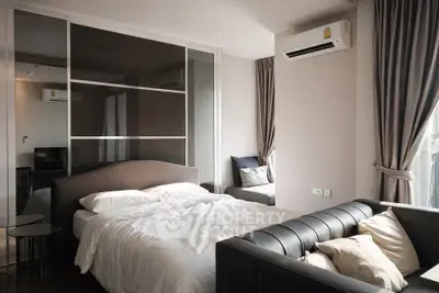 Modern bedroom with stylish decor and natural light, featuring a cozy bed and elegant furnishings.