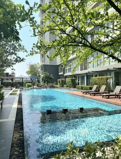 Luxurious apartment complex with a stunning outdoor pool and lush greenery.