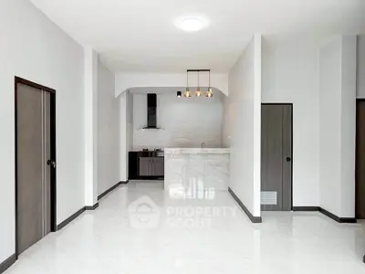 Spacious modern living room with sleek kitchen and elegant lighting