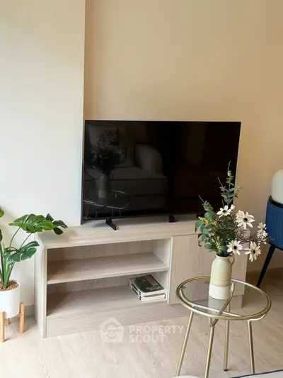 Modern living room with TV, stylish furniture, and decorative plants creating a cozy ambiance.
