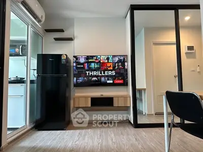 Modern living room with TV, sleek furniture, and kitchen view in stylish apartment.