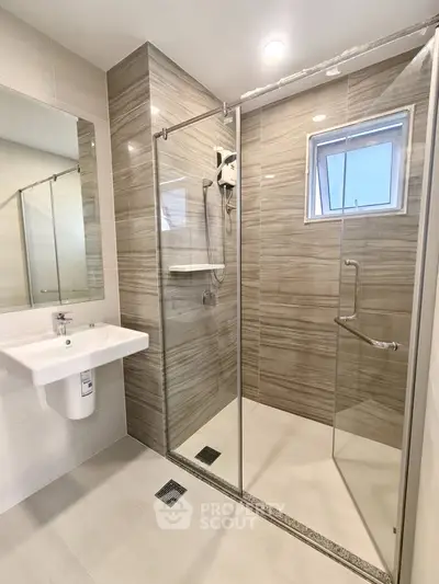Modern bathroom with glass shower enclosure and sleek fixtures