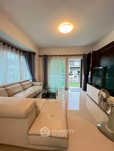 Spacious living room with modern decor and large windows offering natural light.