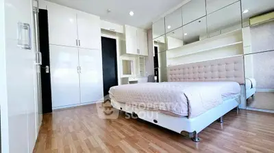 Modern bedroom with mirrored walls and sleek wooden flooring