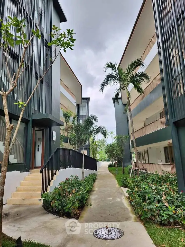Modern apartment complex with lush greenery and sleek architectural design.