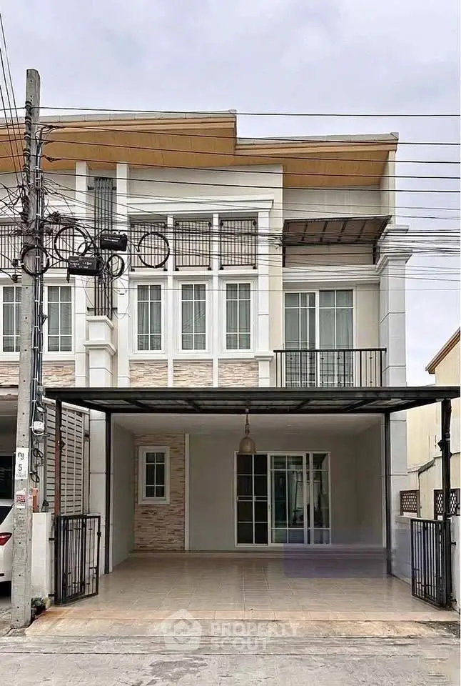 Modern townhouse exterior with spacious carport and stylish facade.