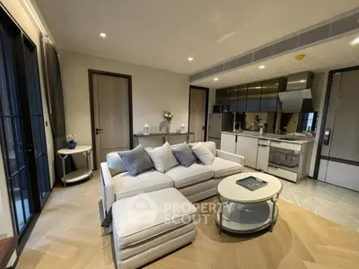 Modern living room with sleek kitchen, cozy sofa, and elegant decor in open layout apartment.