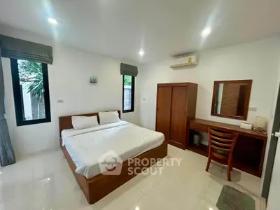 Spacious bedroom with modern furnishings and natural light in a serene setting.