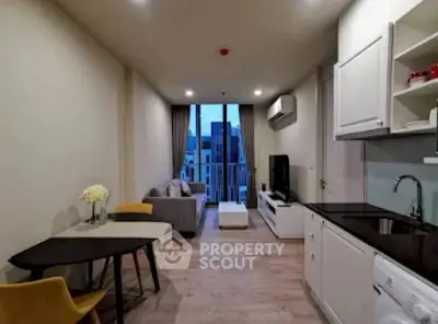 Modern open-plan living room with kitchen, featuring sleek furniture and a city view from the balcony.