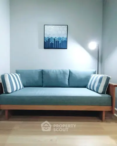 Modern living room with stylish blue sofa and elegant wall art, perfect for cozy relaxation.