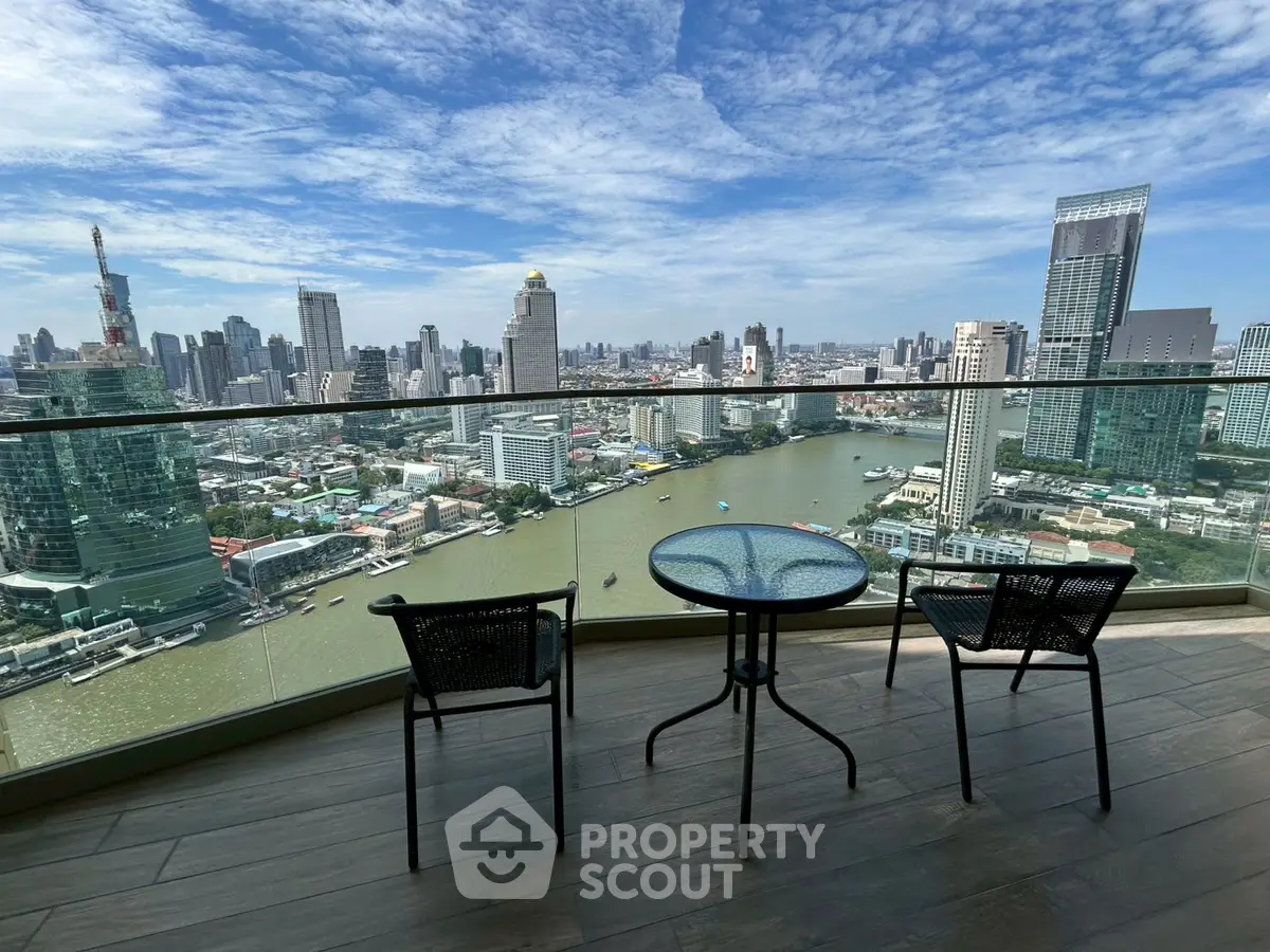 Stunning cityscape view from a high-rise balcony with modern seating, overlooking a river and skyline.