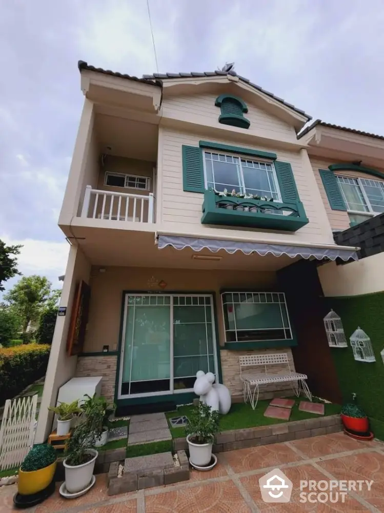 Charming two-story house with balcony and garden, perfect for family living.