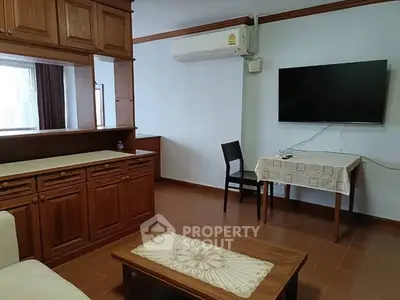 Cozy living room with wooden cabinetry and modern amenities, perfect for relaxation.