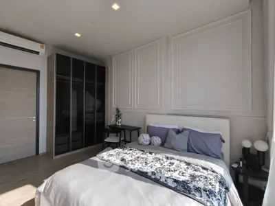 Modern bedroom with stylish decor, large wardrobe, and natural light.