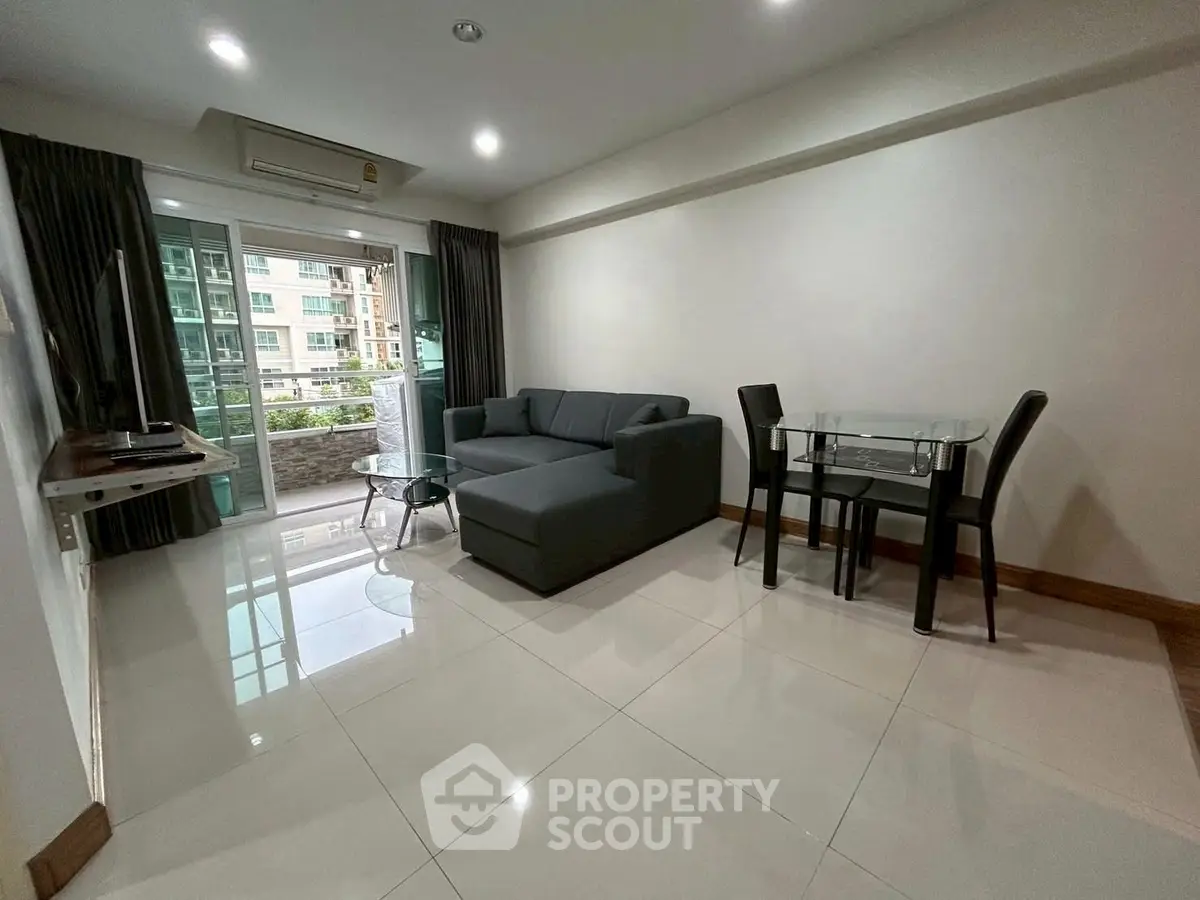 Modern living room with sleek furniture and balcony view in urban apartment.