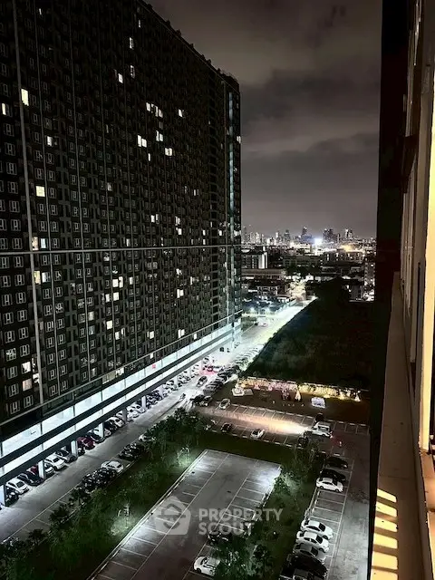 Stunning night view of cityscape from high-rise building with illuminated parking area.