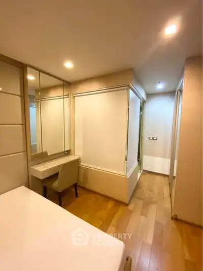 Modern bedroom with wooden flooring and stylish furniture