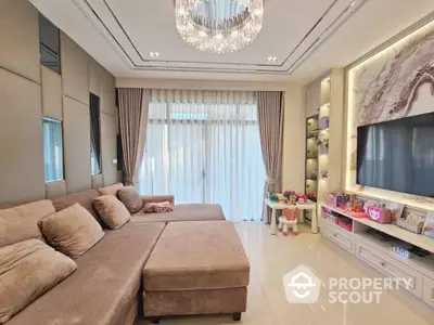 Luxurious living room with plush sofa and elegant chandelier, perfect for family gatherings.