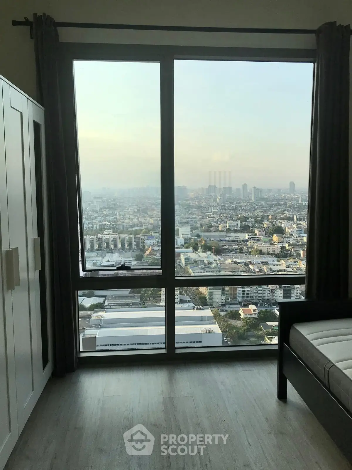 Stunning city view from a modern high-rise apartment bedroom window.