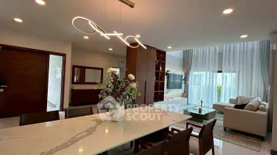 Luxurious open-plan living and dining area with modern lighting and elegant decor.