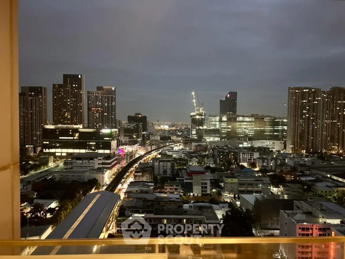 Stunning cityscape view from a high-rise balcony at dusk with vibrant city lights.