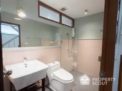 Modern bathroom with glass shower and sleek fixtures in contemporary home.