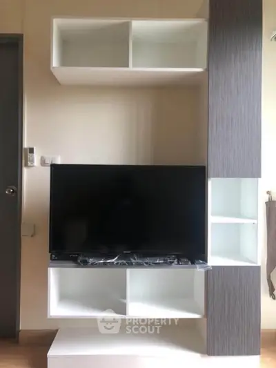 Modern living room with sleek TV unit and ample storage space.