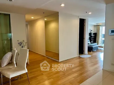 Spacious modern living area with wooden flooring and elegant dining setup.