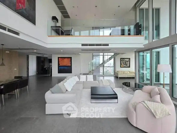 Luxurious open-plan living room with modern decor and expansive windows offering stunning views.