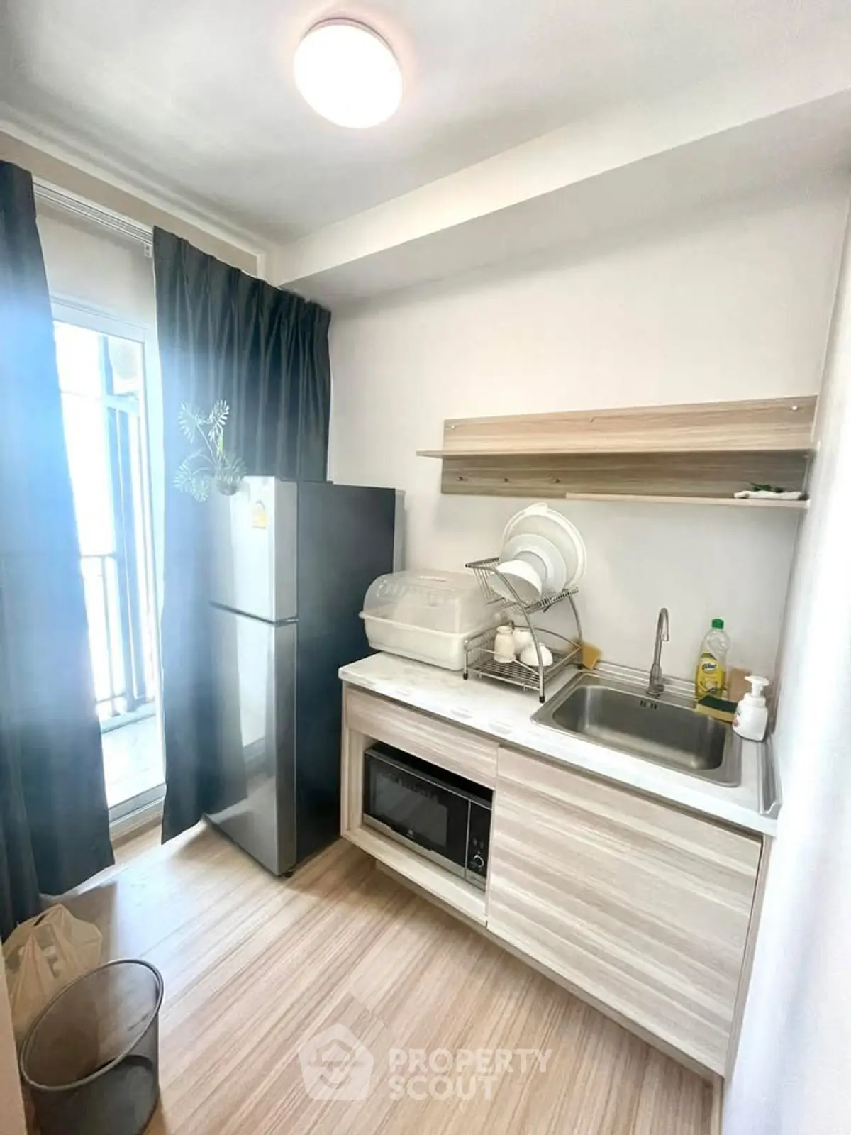 Modern compact kitchen with sleek appliances and balcony access