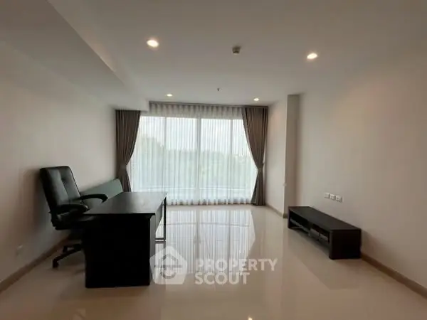 Spacious office room with large window and modern furnishings