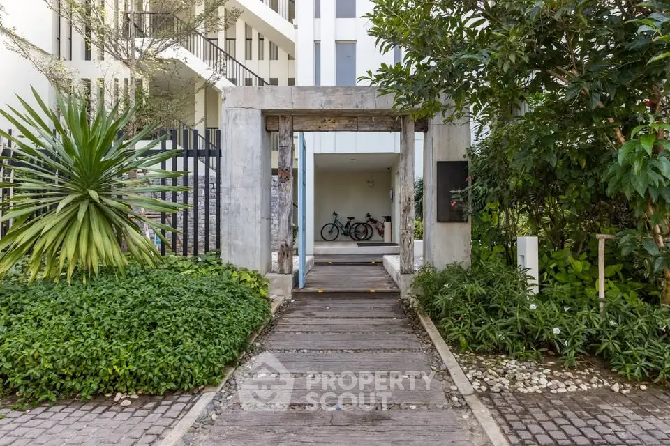 Charming building entrance with lush greenery and modern design