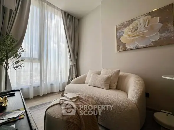 Elegant living room with plush sofa and large window offering natural light.