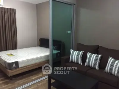 Cozy studio apartment with modern furnishings and sliding glass partition.