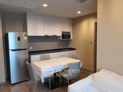 Modern kitchen with dining area featuring sleek cabinetry and stainless steel appliances.