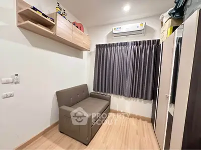 Cozy study room with sofa and storage, featuring modern air conditioning and wooden flooring.