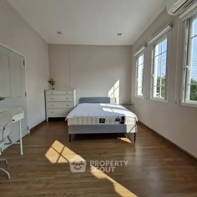 Spacious bedroom with natural light and modern furnishings