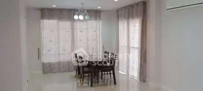 Spacious dining area with elegant curtains and modern lighting